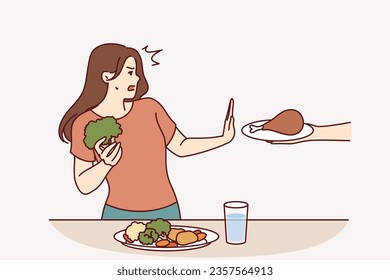 Vegetarian woman refuses meat and makes stop gesture in fear while eating fresh vegetables. Vegetarian girl says no to person offering junk high-calorie food and leads healthy lifestyle