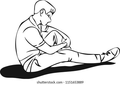 A very sad young man is sitting alone on the floor thinking so deeply.