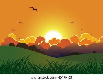 Vibrant orange sun setting behind a mountain range