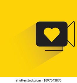 video camera and heart with drop shadow on yellow background