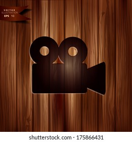 Video camera icon. Cinema symbol. Wooden texture.