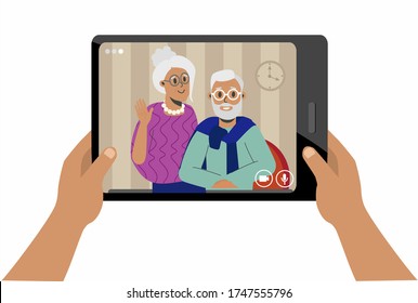 Video chat with elderly parents. Hands holding a tablet on which family, grandparents greet. The long-distance family and comfort concept because of the Covid-19 pandemic,a new outbreak of coronavirus