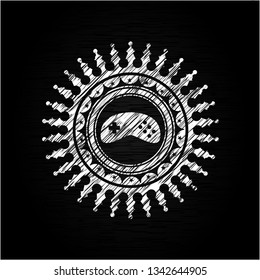 video game icon inside chalkboard emblem written on a blackboard