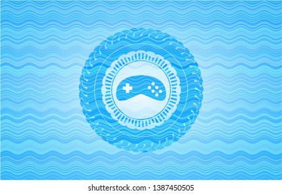 video game icon inside light blue water style emblem.