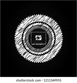 video player icon inside chalkboard emblem written on a blackboard