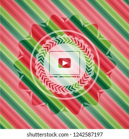 video player icon inside christmas colors emblem.