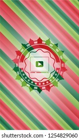 video player icon inside christmas colors style badge.