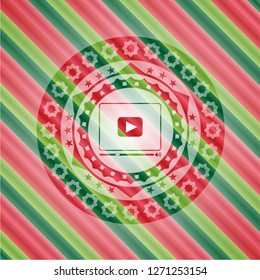 video player icon inside christmas emblem.