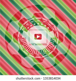 video player icon inside christmas colors style badge.