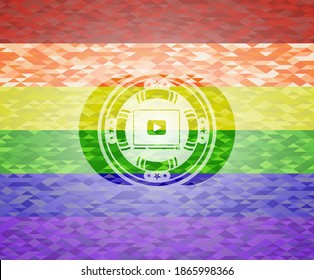 video player icon inside emblem on mosaic background with the colors of the LGBT flag. 