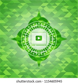 video player icon inside green emblem with triangle mosaic background