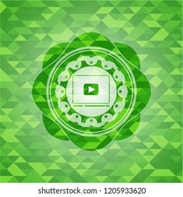 video player icon inside green emblem with mosaic ecological style background