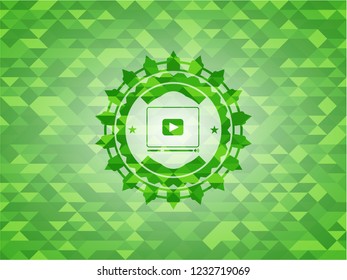 video player icon inside green emblem. Mosaic background