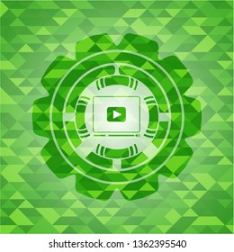 video player icon inside green emblem with triangle mosaic background