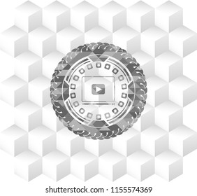 video player icon inside grey emblem with geometric cube white background