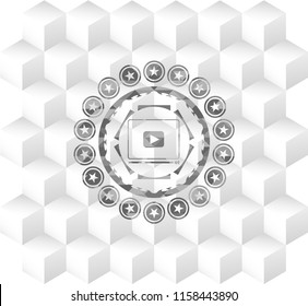 video player icon inside grey badge with geometric cube white background