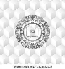 video player icon inside grey emblem with geometric cube white background