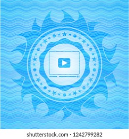 video player icon inside light blue water badge background.