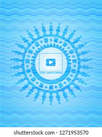 video player icon inside light blue water wave badge background.
