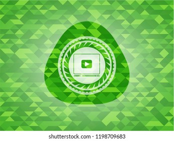 video player icon inside realistic green emblem. Mosaic background