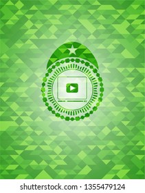video player icon inside realistic green emblem. Mosaic background