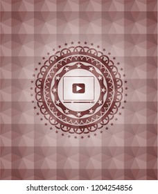 video player icon inside red seamless emblem or badge with abstract geometric polygonal pattern background.