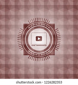 video player icon inside red seamless emblem or badge with abstract geometric polygonal pattern background.