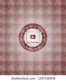 video player icon inside red seamless geometric emblem.