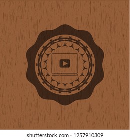 video player icon inside retro style wood emblem