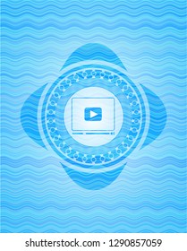 video player icon inside sky blue water wave emblem.