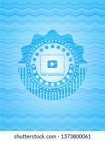 video player icon inside water wave representation emblem.