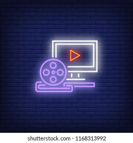 Video production neon sign. Luminous signboard with computer and film reel. Night bright advertisement. Vector illustration in neon style for footage production, video editing, cinematography