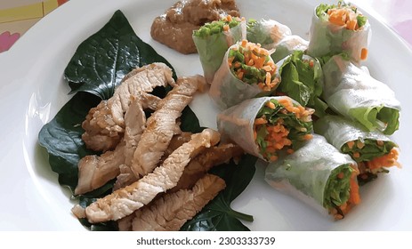 Vietnamese food, grilled pork and spring roll with vegetables on the white plate