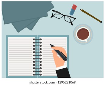 view from above businessman writing. Table with cup of coffee, notebook pen, pencil. 