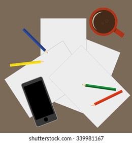 View from above of a desktop with blank sheets of paper, pencils a mobile phone and a cup of coffee as preparation for paperwork or sketching