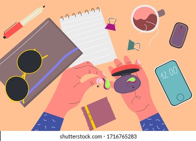 View from above. Men's holds box from under the hearing aid. Notebooks, sunglasses, phone, wipe, pen, clamps, cup of tea, device. Colorful vector illustration in flat cartoon style.