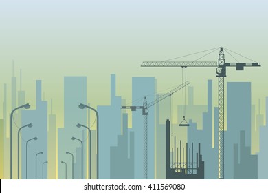 view of the city with tower cranes and street lamps in the foreground