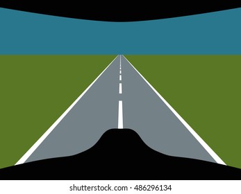 View of the roadway with green grassy roadside out the crash helmet.