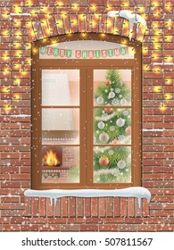View through a window on the interior of a Christmas living room with the Christmas tree and fireplace. The brick facade of the house decorated with LED light glowing garland.