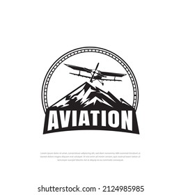 Vintage airplane logo design. Retro Grunge Airplane with emblem logo, air transport in sky on mountain background