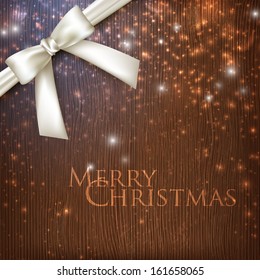 vintage Christmas background with sparkles, white bow and wooden texture