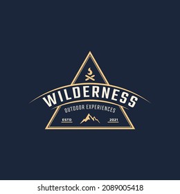 Vintage Emblem Badge Wilderness Mountain Adventure Logo with Bonfire Symbol for Outdoor Camp in Retro Style Vector Illustration