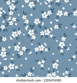 Vintage floral background. Floral pattern with white flowers and dark blue leaves on a blue background. Seamless pattern for design and fashion prints.Stock vector illustration.