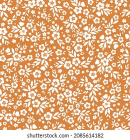 Fondo floral vintage. Patrón vectorial transparente para el diseño y las impresiones de moda. Patrón floral con flores blancas pequeñas y hojas sobre un fondo de terracota.