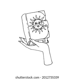 Vintage Gold and Black Mystic Spell Book with sun on cover in female hand Illustration