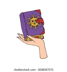 Vintage Gold and Black Mystic Spell Book with sun on cover in female hand Illustration