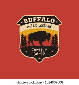 Vintage hand drawn wildlife logo patch with bison, forest and quote - Buffalo Wild Zone - Family Camp. Old style outdoors camping emblem in retro style for prints. Stock vector illustration.