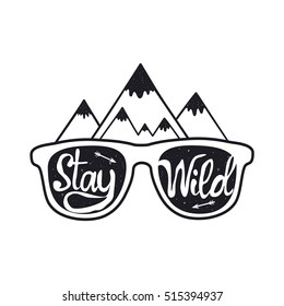 Vintage hipster vector illustration. Hand drawn style typography poster with sunglasses, mountains, arrows and quote. Stay Wild. T-shirt print, inspirational and motivational design