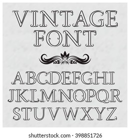 Vintage letters with flourishes. Vintage font in baroque style. Vintage latin alphabet. Black outline capital letters on a gray textured background.