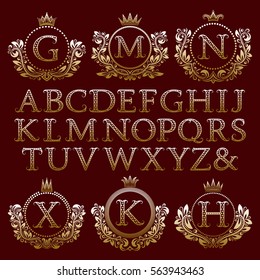 Vintage monogram kit. Starry gold letters and floral coat of arms frames for creating initial logo in antique style.
